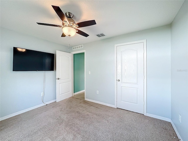 unfurnished bedroom featuring light carpet, ceiling fan, and a closet