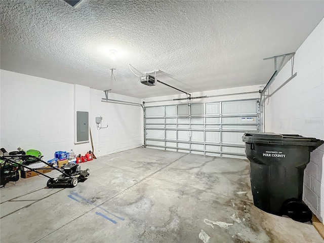 garage with a garage door opener and electric panel