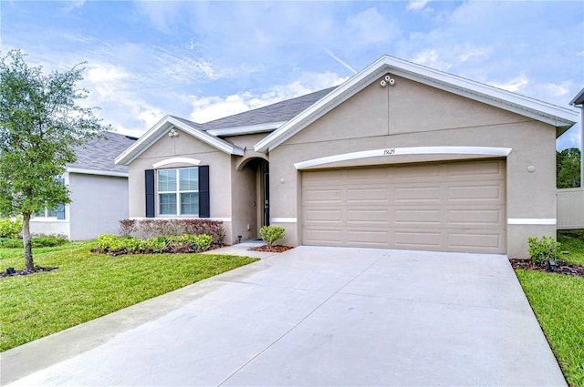 ranch-style house featuring a front yard and a garage