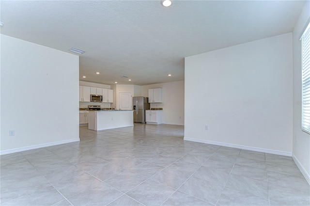 unfurnished living room featuring a healthy amount of sunlight and light tile patterned floors