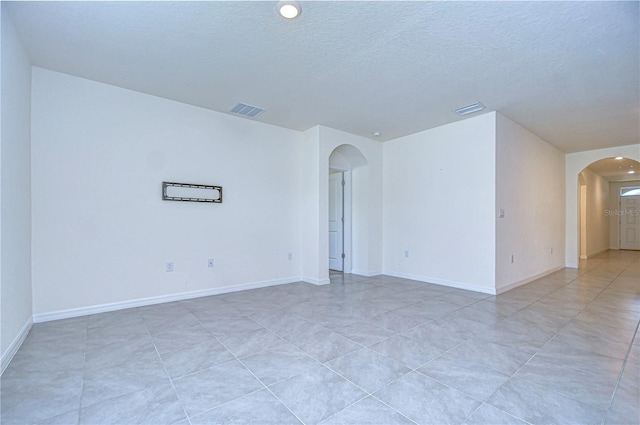 unfurnished room featuring a textured ceiling