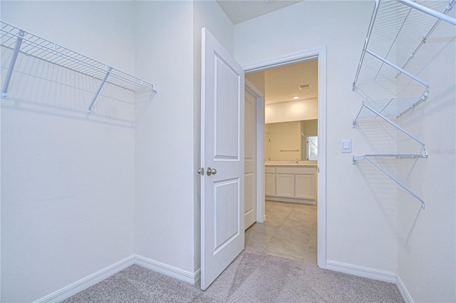 spacious closet with light carpet and sink