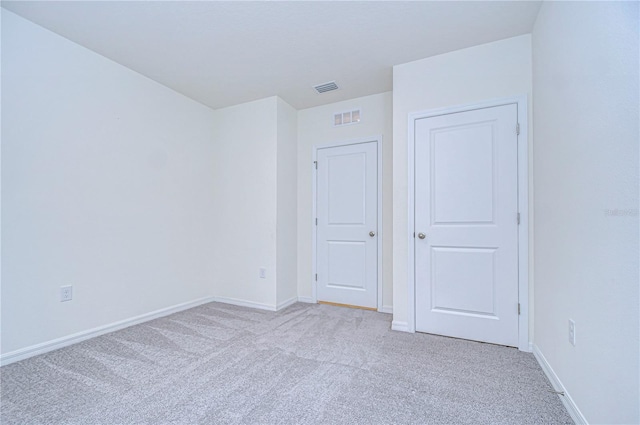 spare room featuring light colored carpet