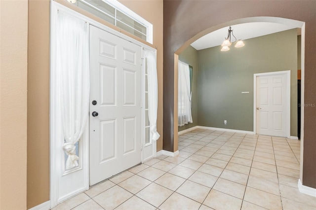 tiled entrance foyer featuring an inviting chandelier