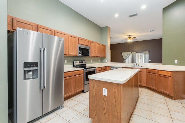 kitchen featuring sink, kitchen peninsula, a kitchen island, stainless steel appliances, and ceiling fan