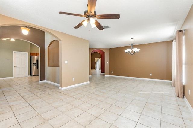 tiled spare room featuring ceiling fan with notable chandelier