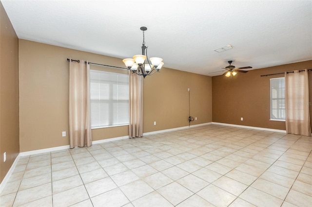 unfurnished room with ceiling fan with notable chandelier, a wealth of natural light, and a textured ceiling