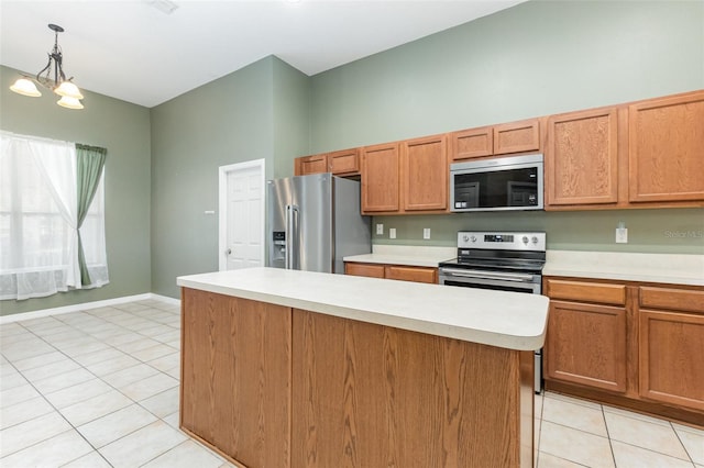 kitchen featuring pendant lighting, light tile patterned flooring, a kitchen island, appliances with stainless steel finishes, and a notable chandelier