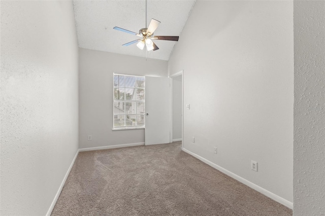 empty room with a textured ceiling, carpet flooring, vaulted ceiling, and ceiling fan