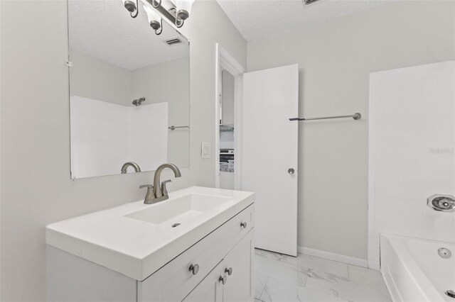 bathroom with shower / tub combination, vanity, and a textured ceiling