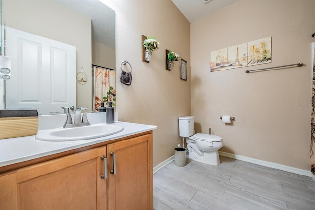 bathroom with vanity, toilet, and hardwood / wood-style floors