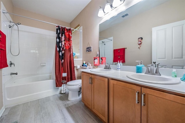 full bathroom featuring vanity, hardwood / wood-style floors, shower / bath combo with shower curtain, and toilet