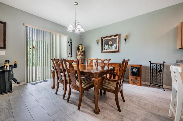 dining area with light hardwood / wood-style floors and an inviting chandelier