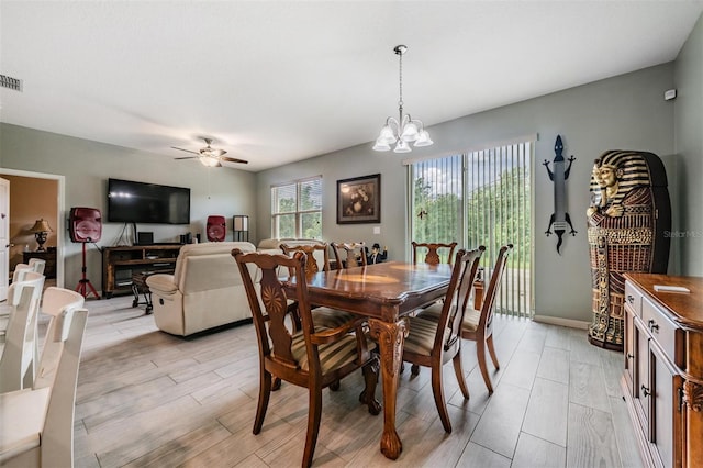 dining room featuring ceiling fan with notable chandelier and light wood-type flooring