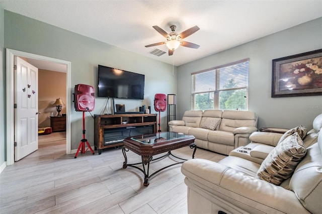 living room featuring ceiling fan and light hardwood / wood-style floors