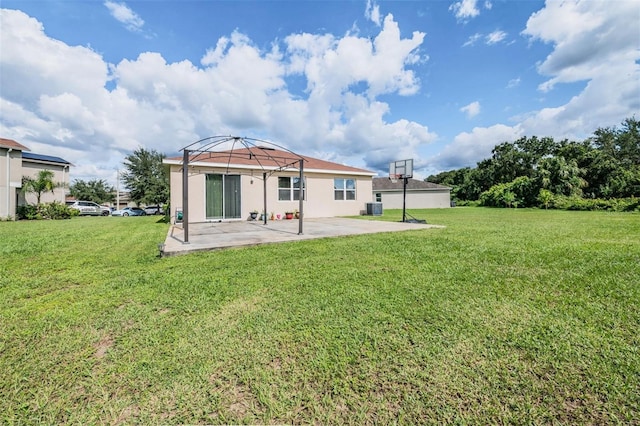 rear view of house with central air condition unit, a patio area, and a yard