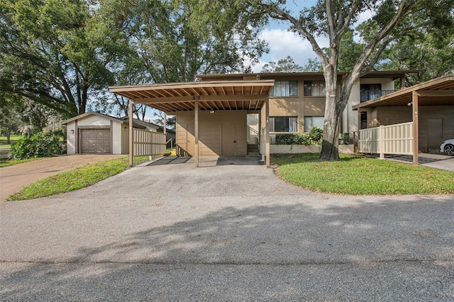 view of front of home with an outdoor structure, a garage, and a carport