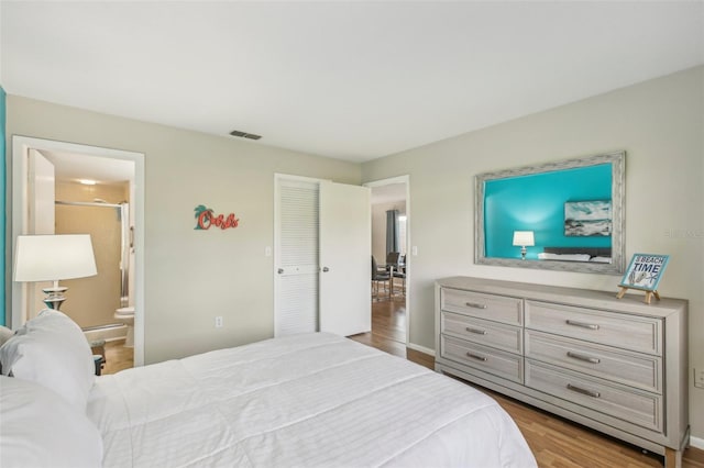 bedroom with a closet, ensuite bathroom, and light hardwood / wood-style floors