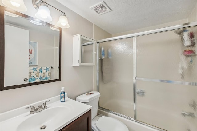 full bathroom featuring vanity, enclosed tub / shower combo, a textured ceiling, and toilet