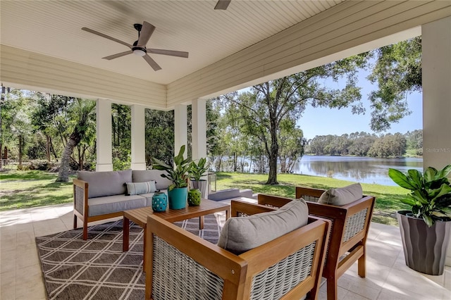 view of patio / terrace featuring ceiling fan, a water view, and an outdoor living space