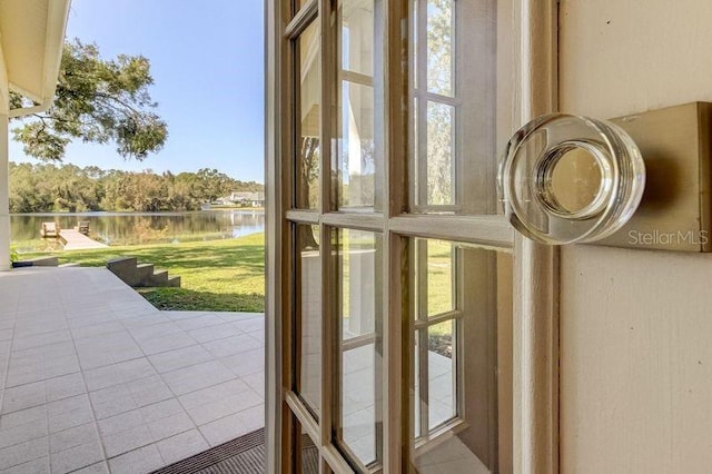 doorway with tile patterned flooring and a water view