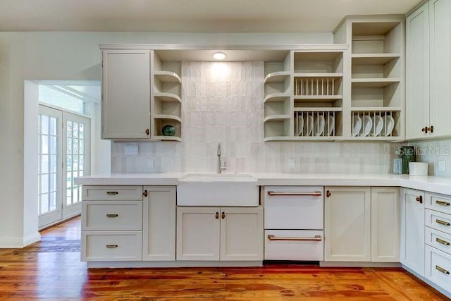 kitchen featuring sink, french doors, tasteful backsplash, light hardwood / wood-style floors, and white cabinets