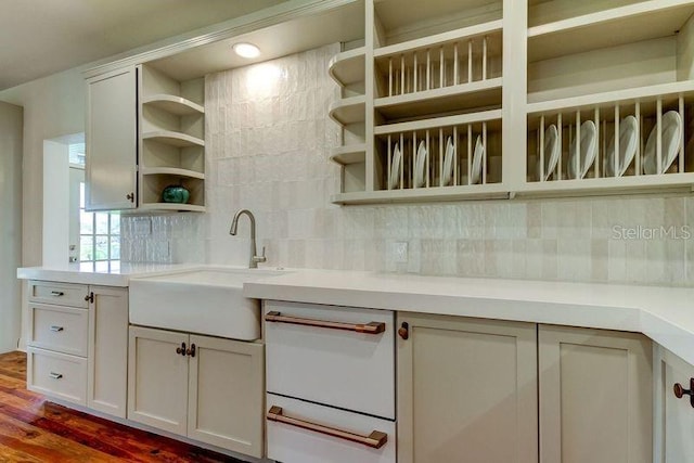 kitchen with backsplash, white cabinetry, sink, and wood-type flooring