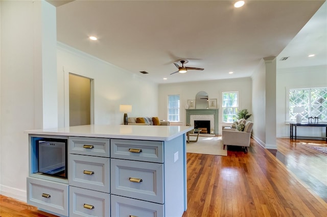 kitchen featuring hardwood / wood-style floors, ceiling fan, and ornamental molding