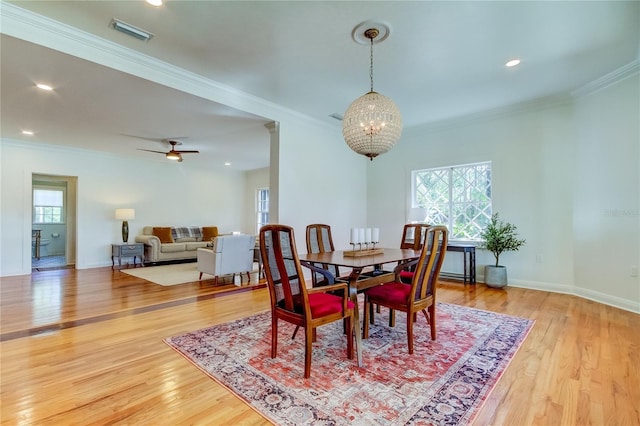 dining space with ceiling fan with notable chandelier, light hardwood / wood-style floors, and ornamental molding