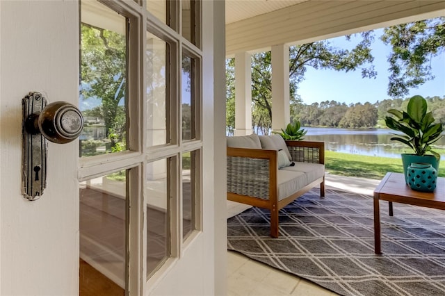 sunroom / solarium featuring a water view