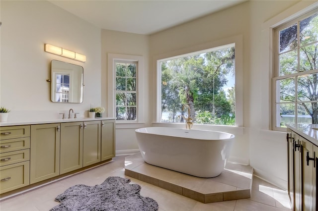 bathroom featuring tile patterned flooring, vanity, and a tub