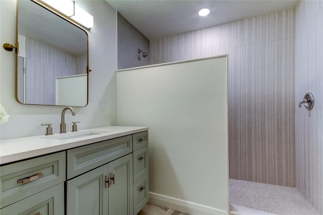 bathroom featuring a tile shower and vanity