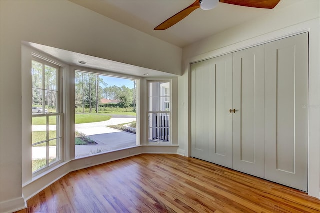 unfurnished bedroom with a closet, light hardwood / wood-style flooring, and ceiling fan