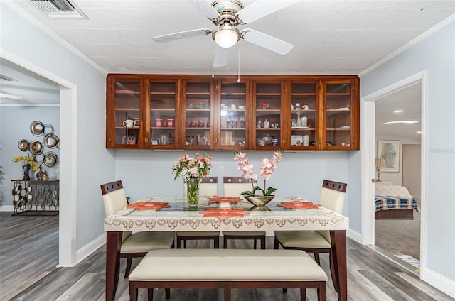 dining space with hardwood / wood-style floors, ceiling fan, and ornamental molding