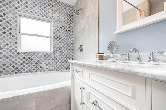 bathroom with tiled shower / bath combo and vanity