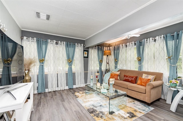 living room featuring ceiling fan, wood-type flooring, and crown molding