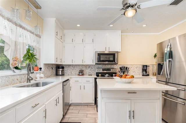 kitchen with sink, hanging light fixtures, ceiling fan, white cabinetry, and stainless steel appliances