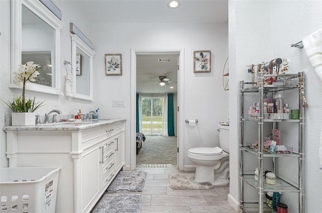 bathroom with vanity, toilet, and ceiling fan