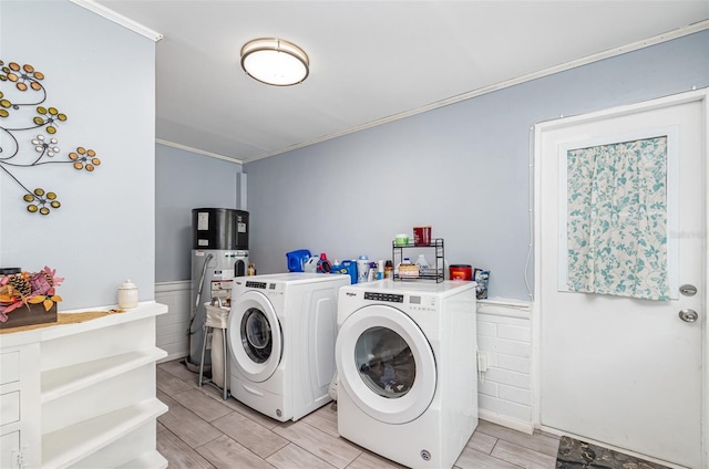 clothes washing area featuring washer and clothes dryer, ornamental molding, and heat pump water heater