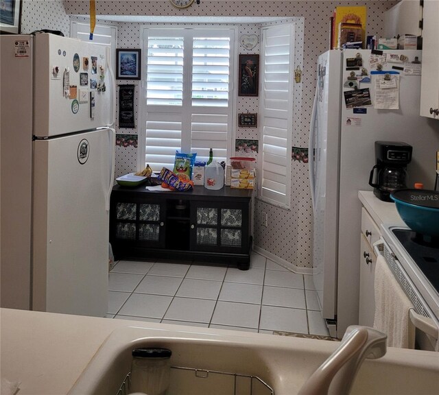 2351 Bentley Dr, Palm Harbor, FL 34684 - kitchen with white appliances, wallpapered walls, light tile patterned floors, and light countertops