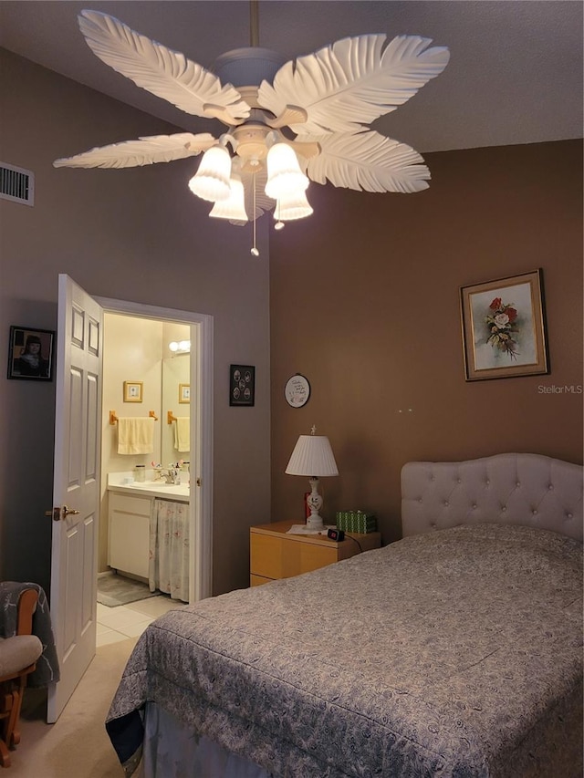 bedroom featuring light carpet, ceiling fan, and ensuite bathroom