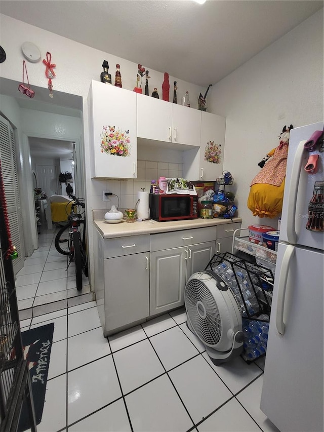 kitchen featuring gray cabinetry, decorative backsplash, white fridge, and light tile patterned flooring