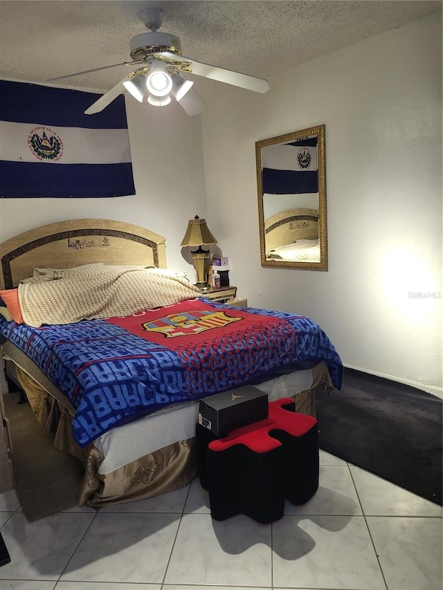 tiled bedroom with ceiling fan and a textured ceiling