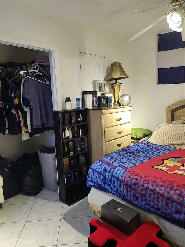 tiled bedroom featuring ceiling fan and a textured ceiling