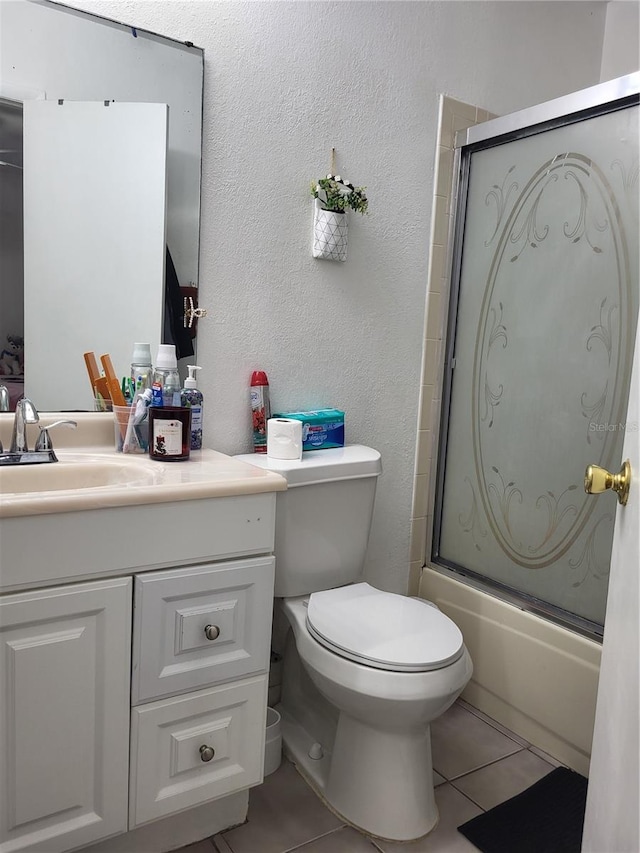 full bathroom featuring tile patterned floors, vanity, toilet, and combined bath / shower with glass door