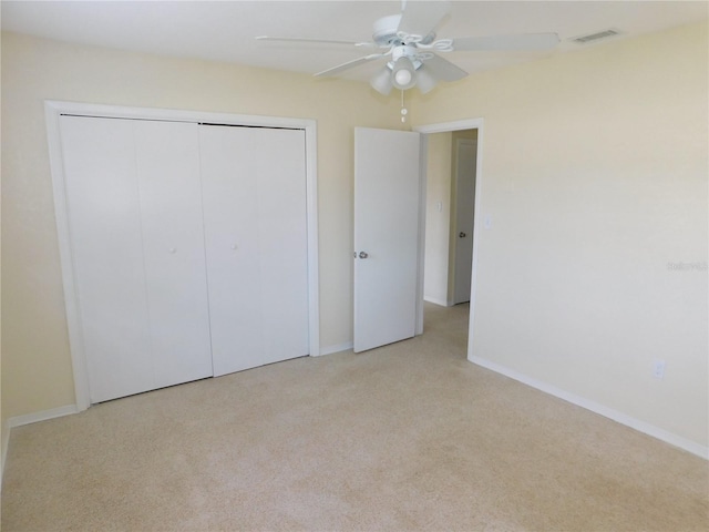 unfurnished bedroom with light carpet, ceiling fan, and a closet