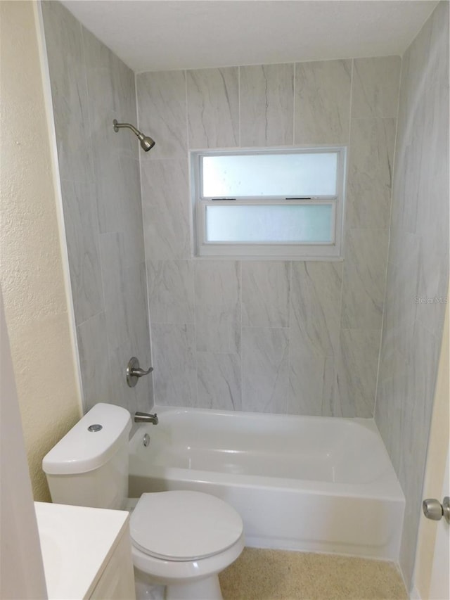 full bathroom featuring tiled shower / bath, vanity, and toilet