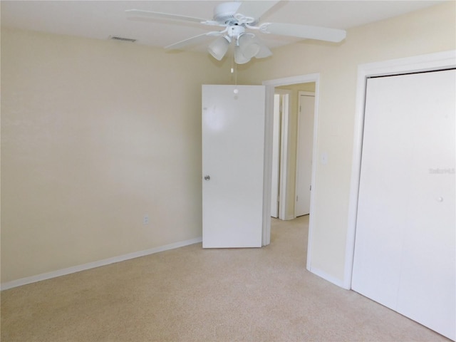 unfurnished bedroom with ceiling fan, a closet, and light colored carpet