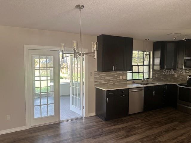 kitchen featuring sink, appliances with stainless steel finishes, hanging light fixtures, and dark hardwood / wood-style flooring