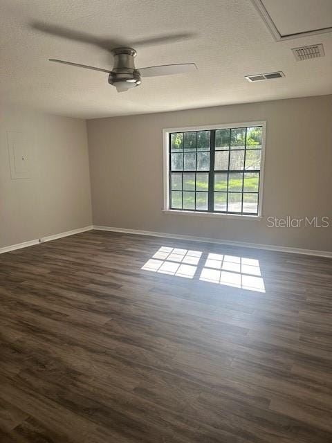 spare room with a textured ceiling, dark wood-type flooring, and ceiling fan